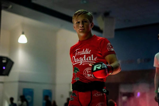 Picture of a fighter wearing a customized Fight Kit, this customized fighting top and shorts for MMA feature his name, personal credo and brand, as well as an English Flag, all of his sponsors, and some symbols that are meaningful to him. 