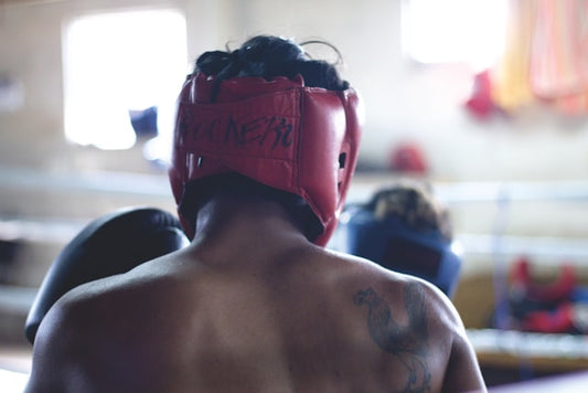 Man with boxing headgear in a boxing ring or MMA cage training for a match 